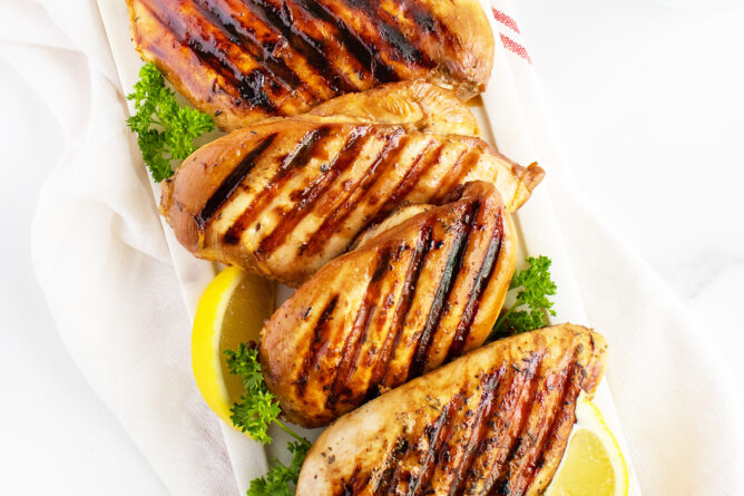 Grilled Chicken Breasts in a line on a cutting board