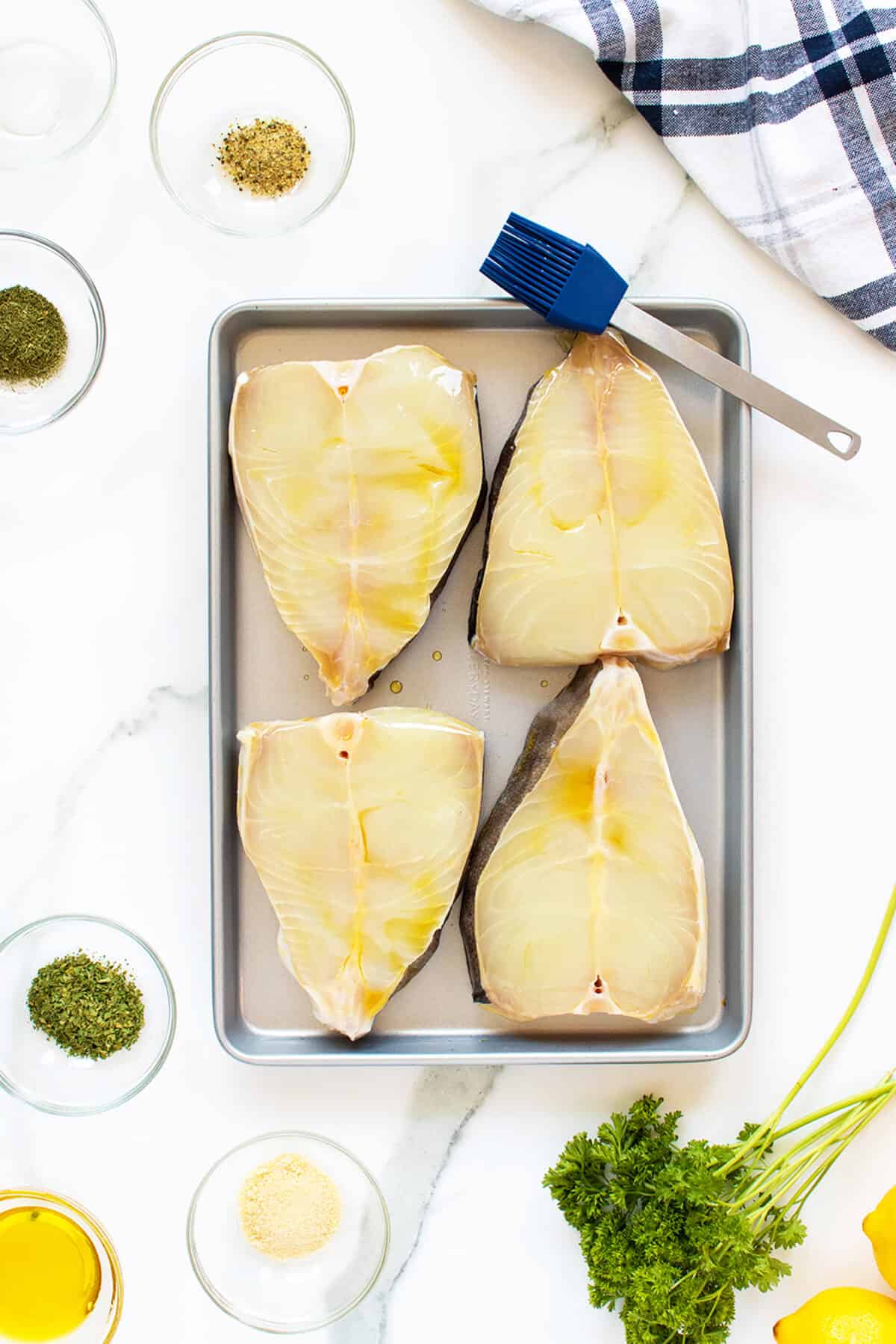 Grilled halibut oiled on a baking sheet