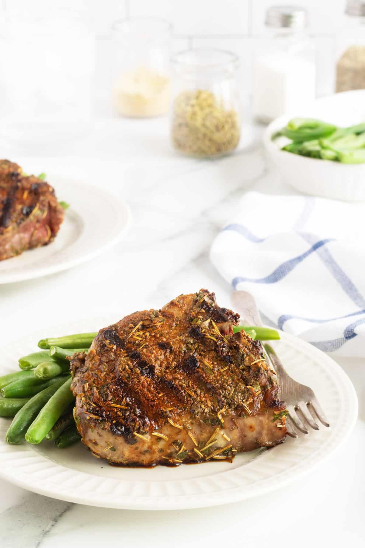 Grilled lamb chops on a white plate with green beans