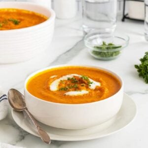 Roasted Carrot Soupin a white bowl with a spoon