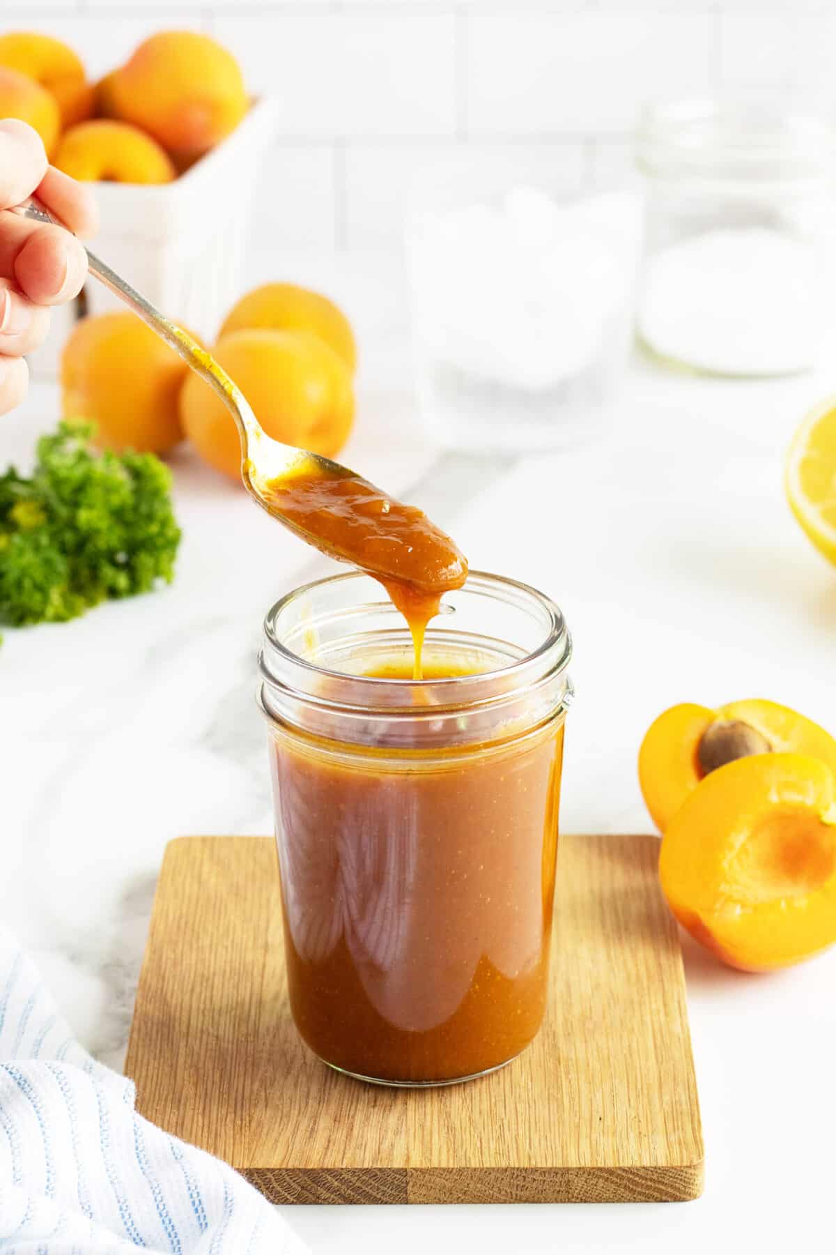 apricot glaze in a jar with a spoon dripping
