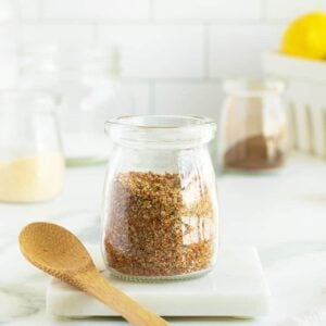 fish seasoning in a jar with a wooden spoon beside