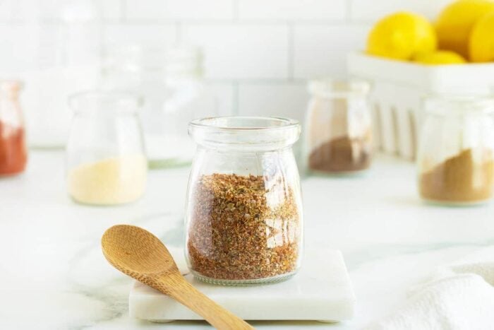 fish seasoning in a jar with a wooden spoon beside