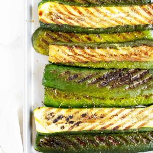 grilled zucchini lined up on a pan