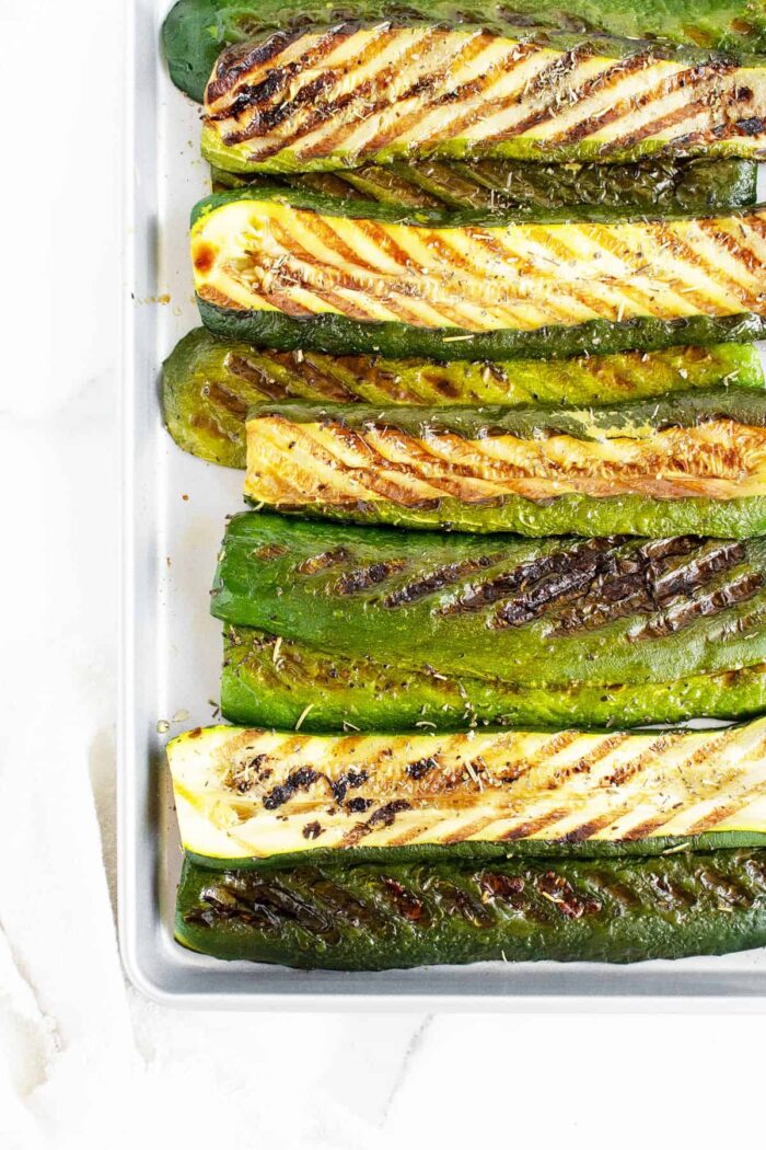 grilled zucchini lined up on a pan