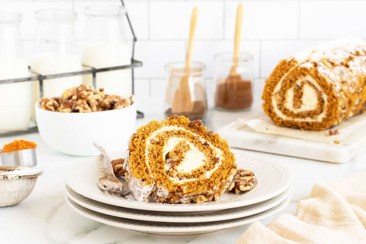 A moist pumpkin roll filled with creamy frosting and dusted with powdered sugar.