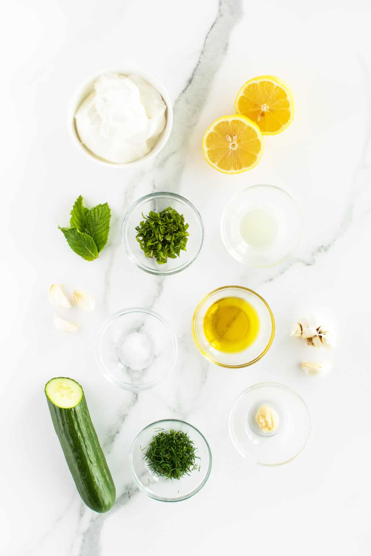 tzatziki sauce ingredients on a white cuttingboard