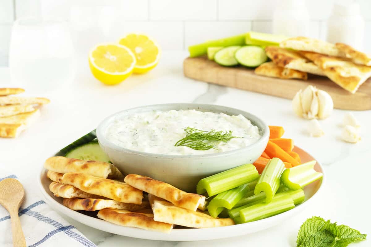 tzatziki sauce on a plate with sliced vegetables