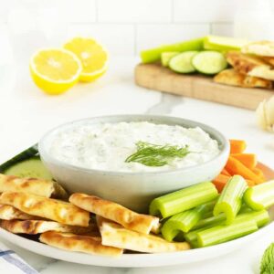 tzatziki sauce on a plate with sliced vegetables
