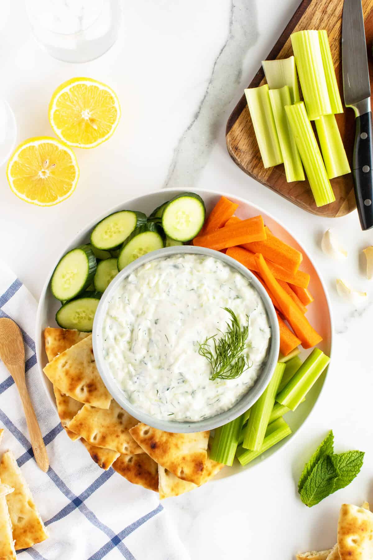 tzatziki sauce in a bowl surrounded by sliced vegetables
