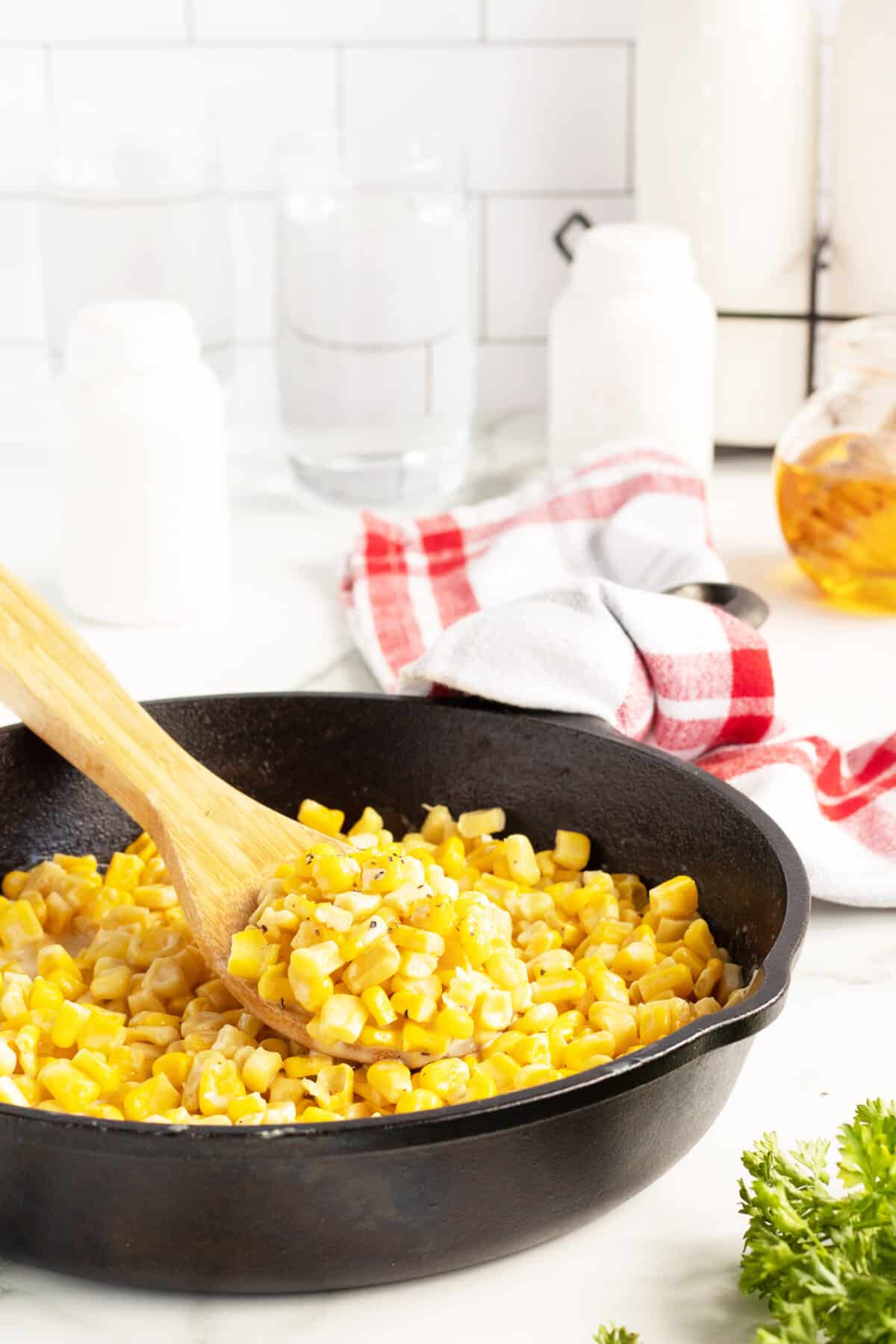 honey butter skillet corn in a black skillet with spoon