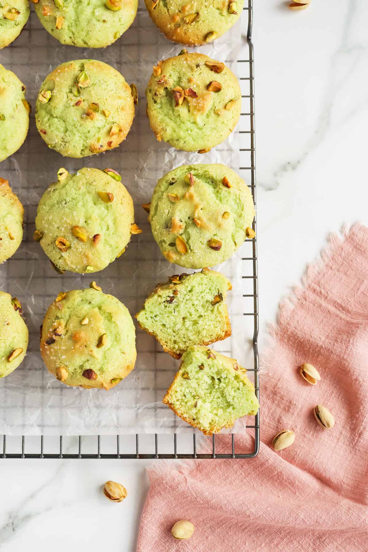Pistachio Muffins on a cooling rack one sliced in half