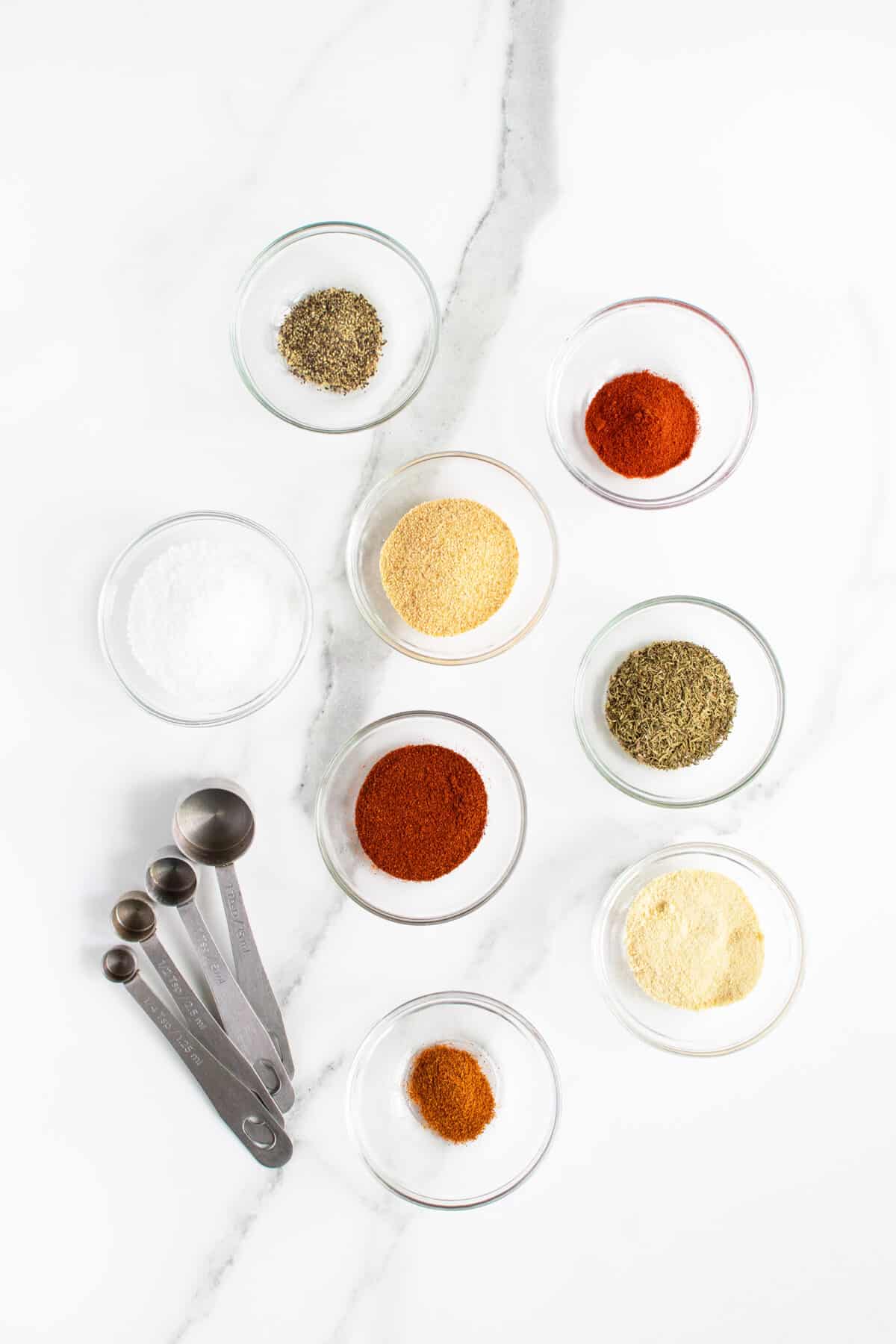 Chicken wing rub ingredients in clear small bowls