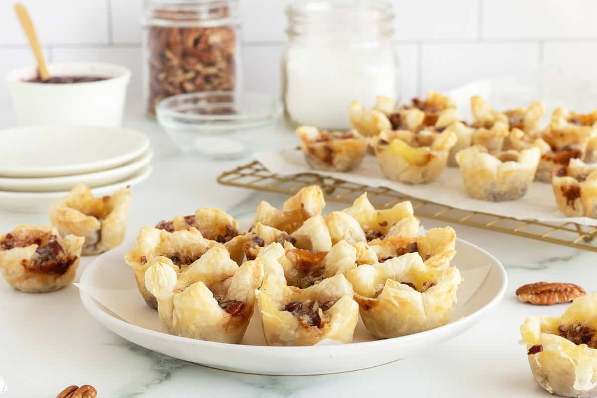 Mini puff pastry cups filled with melted brie and cranberry sauce.