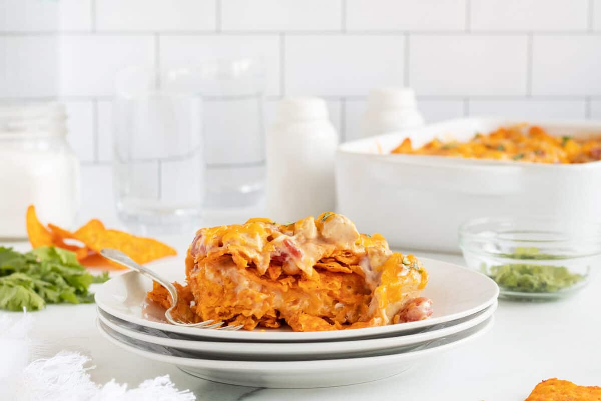 Doritos chicken casserole on a stack of white plates