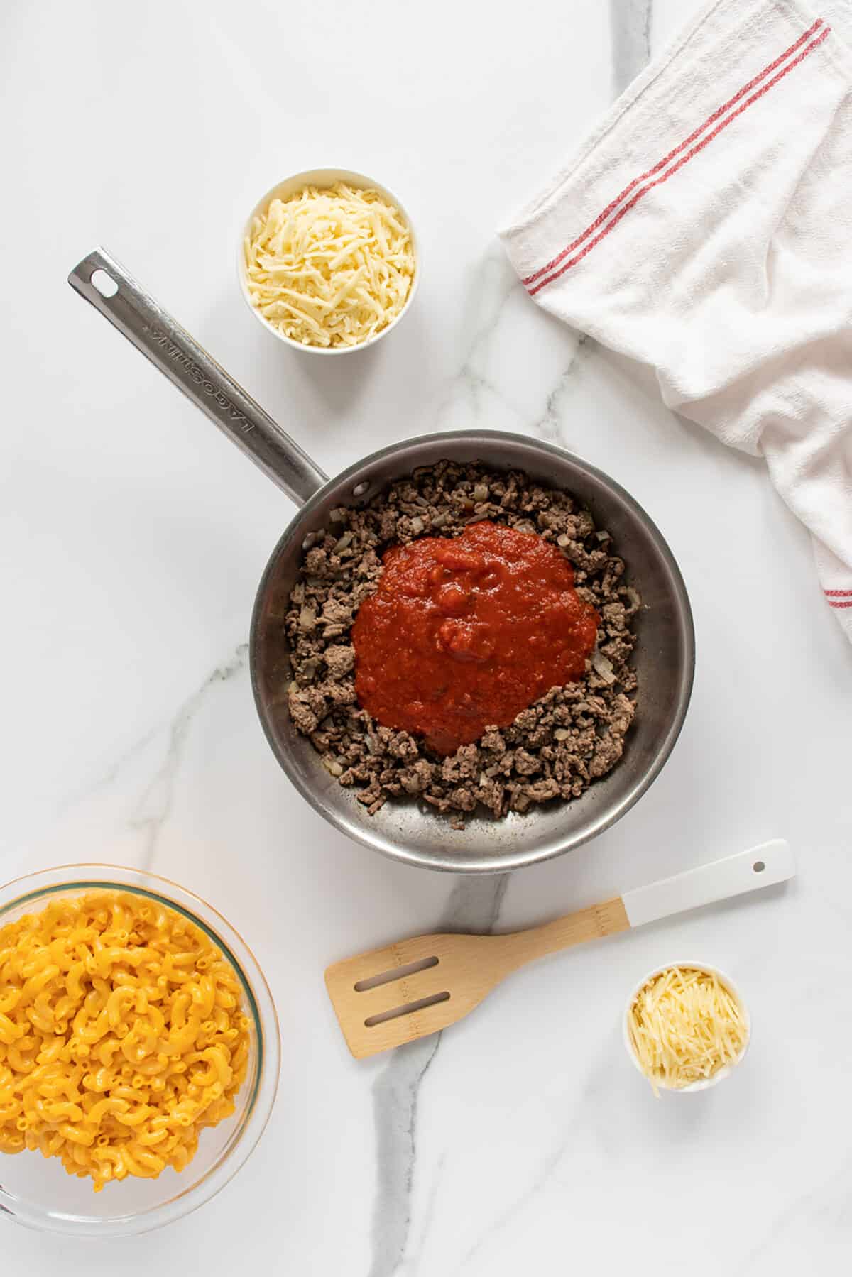 mac and cheese lasagna ground beef in a pan with sauce