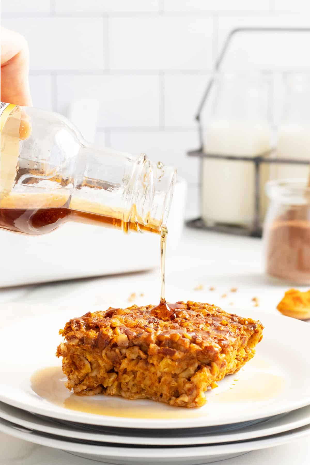 pumpkin baked oatmeal with maple syrup being poured overtop