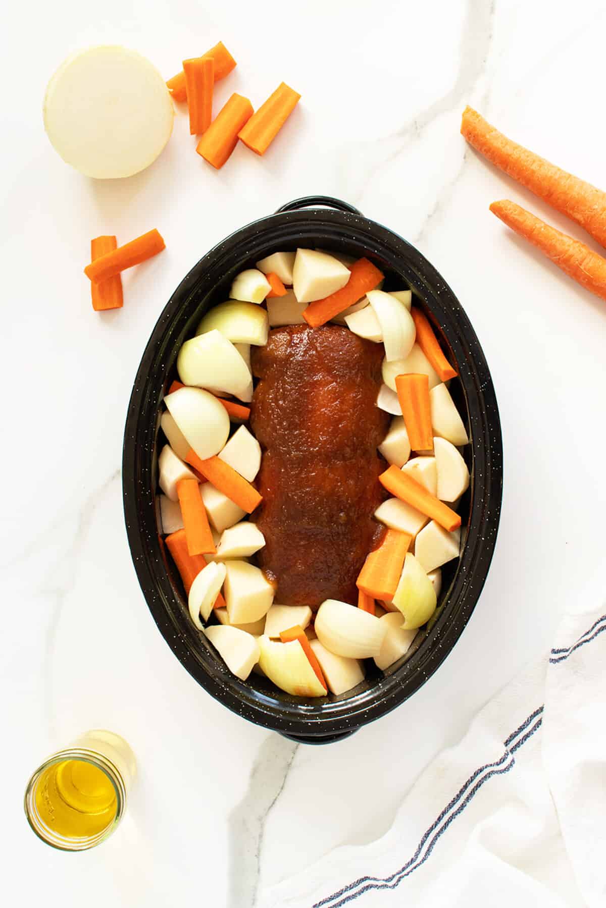 apple butter porkloin uncooked with vegetables in a roaster