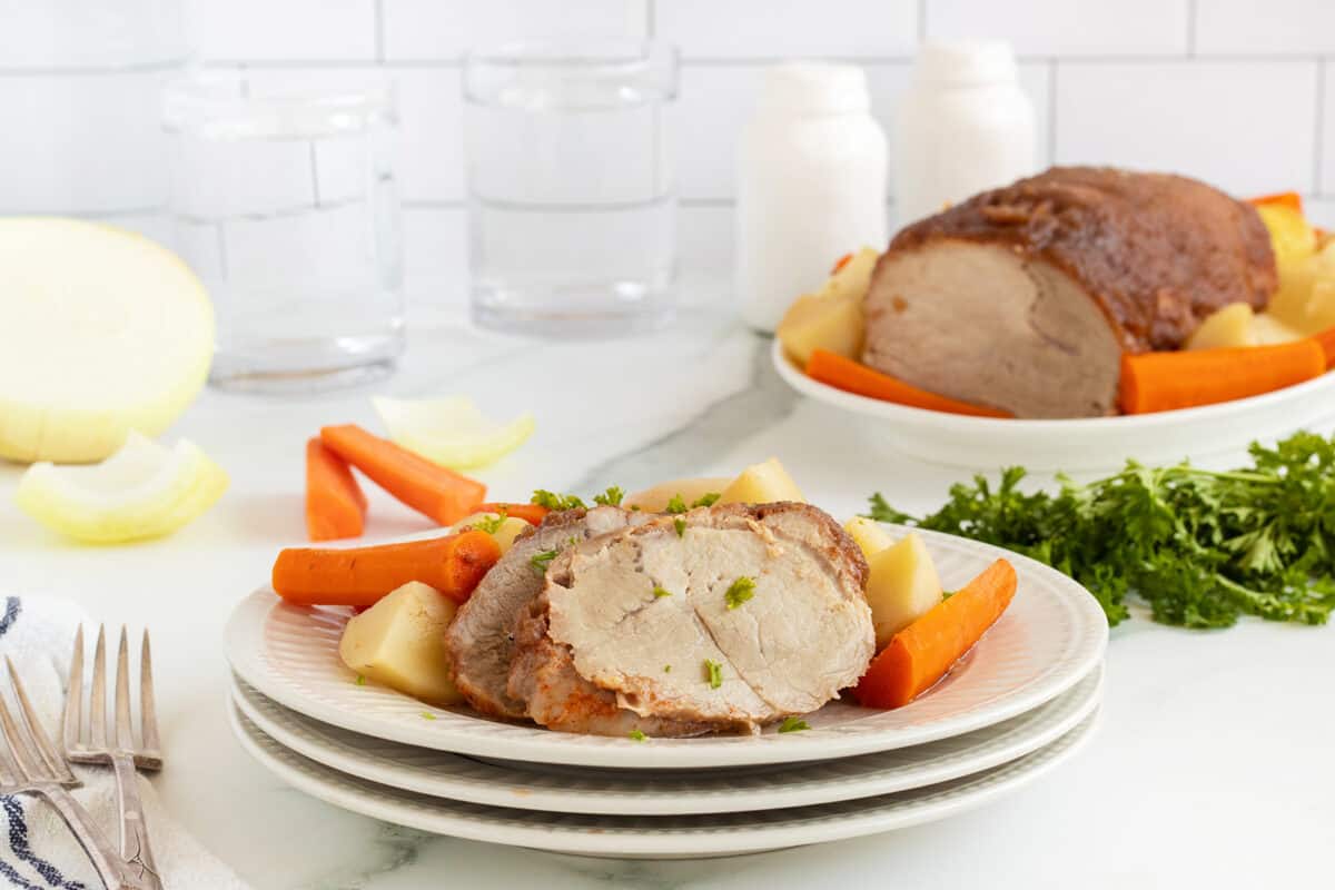apple butter porkloin on a white plate with vegetables