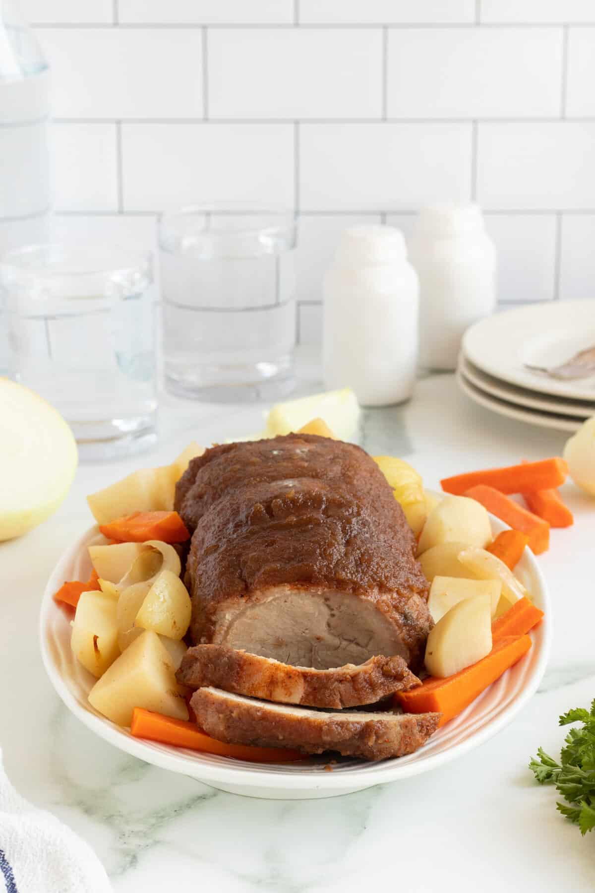 apple butter porkloin sliced on a platter with vegetables