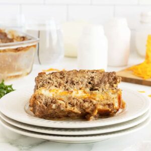 cheese stuffed meatloaf slice on a white plate