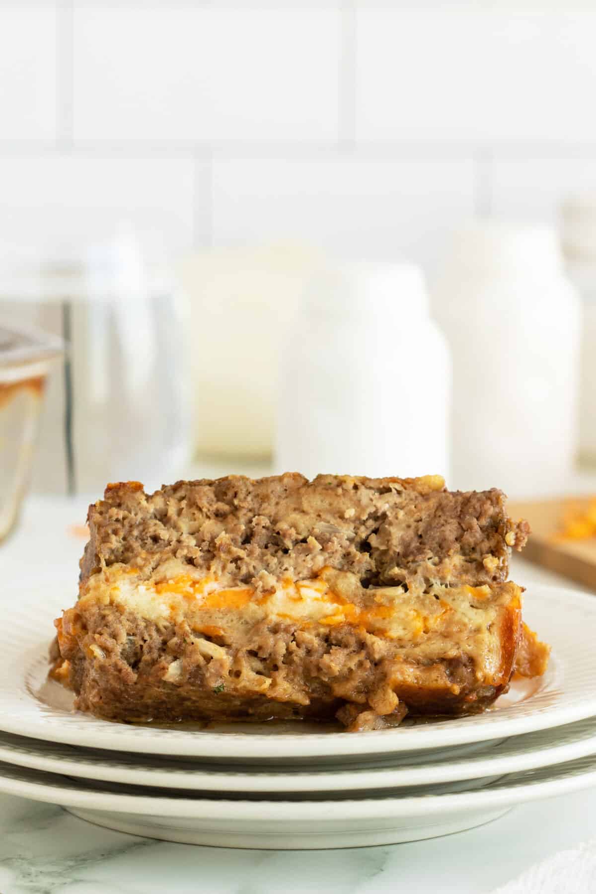 cheese stuffed meatloaf slice on a white plate