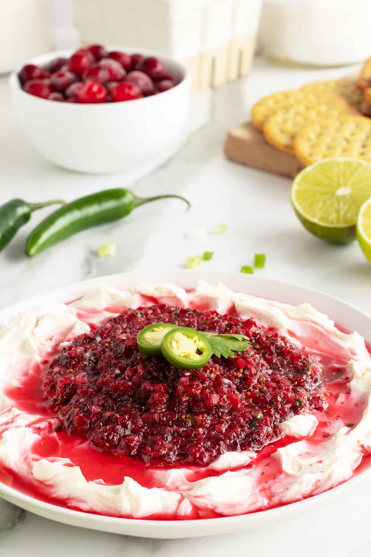 cranberry jalapeno dip on cream cheese on a white plate