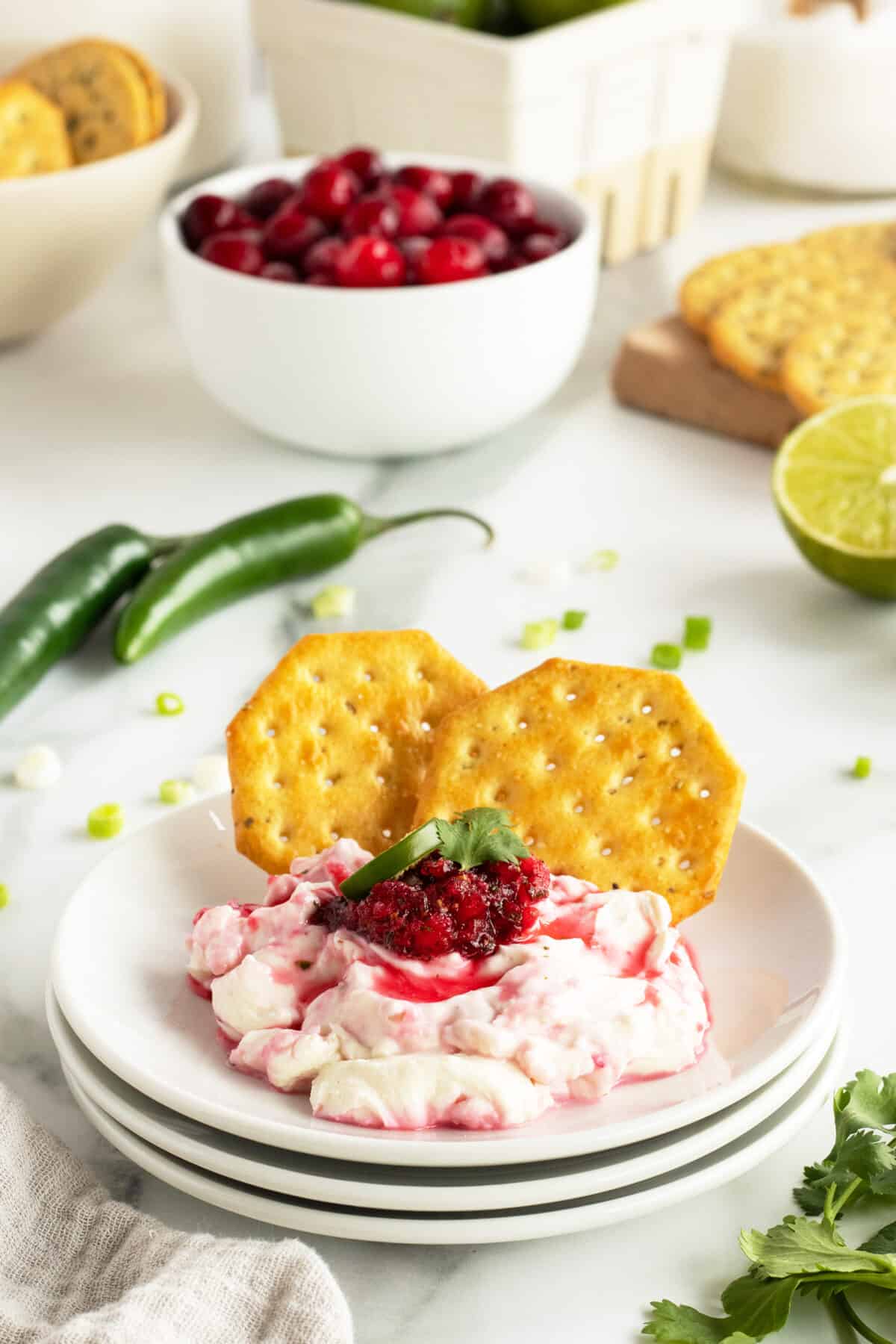 cranberry jalapeno dip on a small plate with two crackers