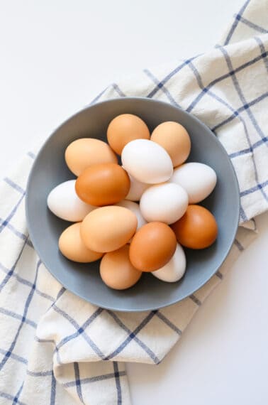 blue bowl with white and brown eggs inside