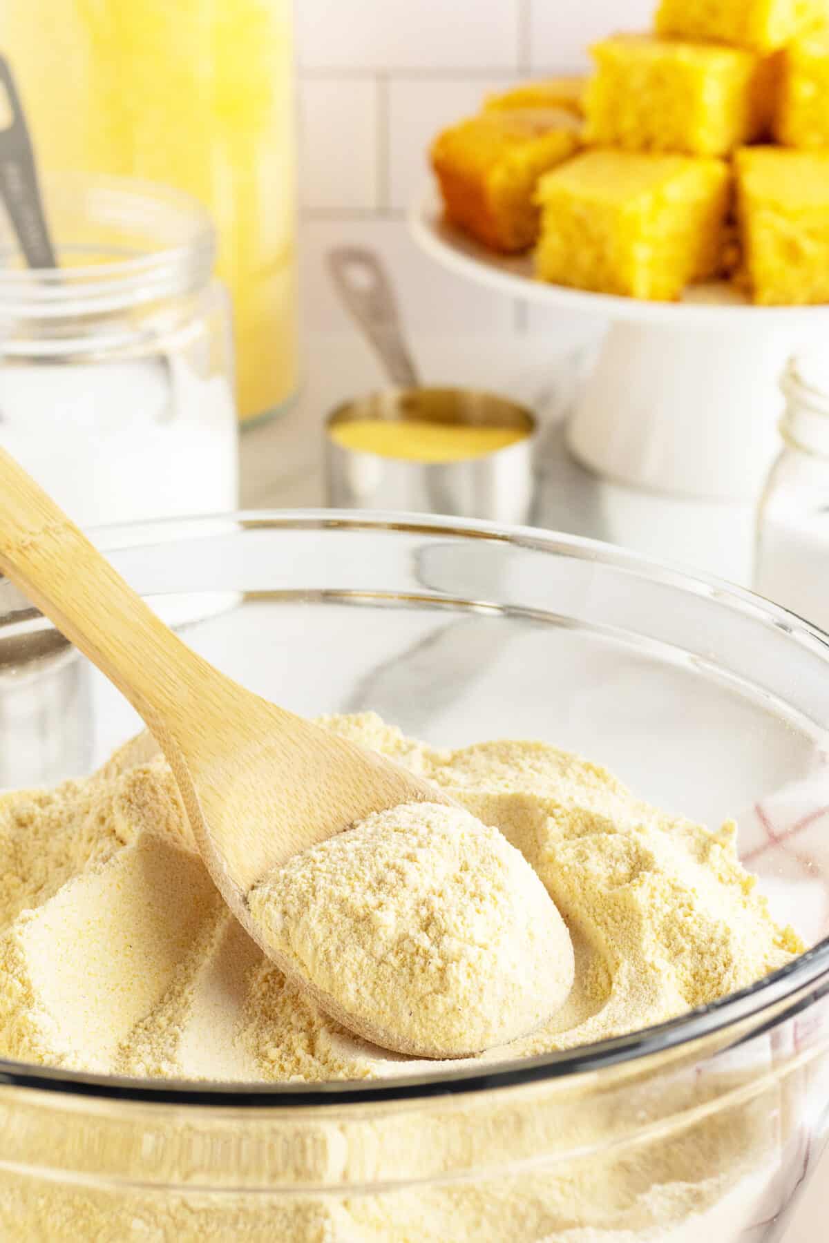 homemade cornbread mix in a bowl and wooden spoon