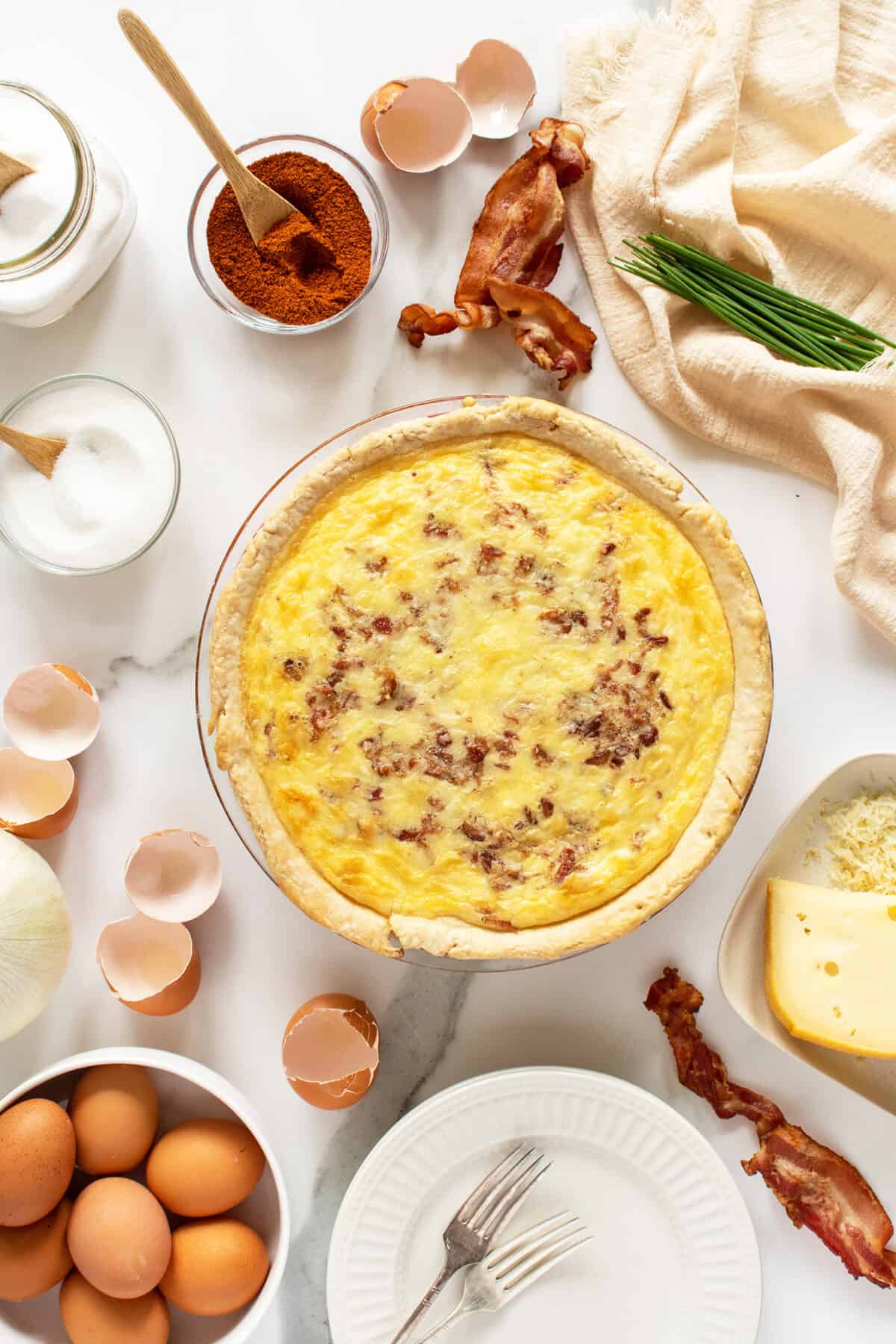 quiche lorraine cooked with ingredients around it