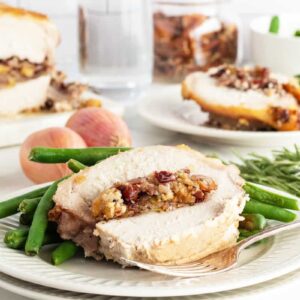 stuffed pork loin withgreen beans on a plate