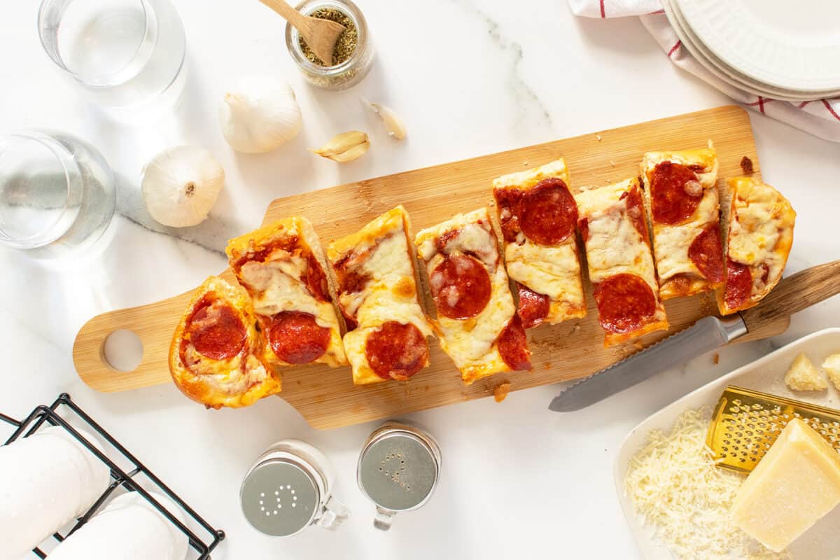 French Bread Pizza sliced on a wooden cutting board