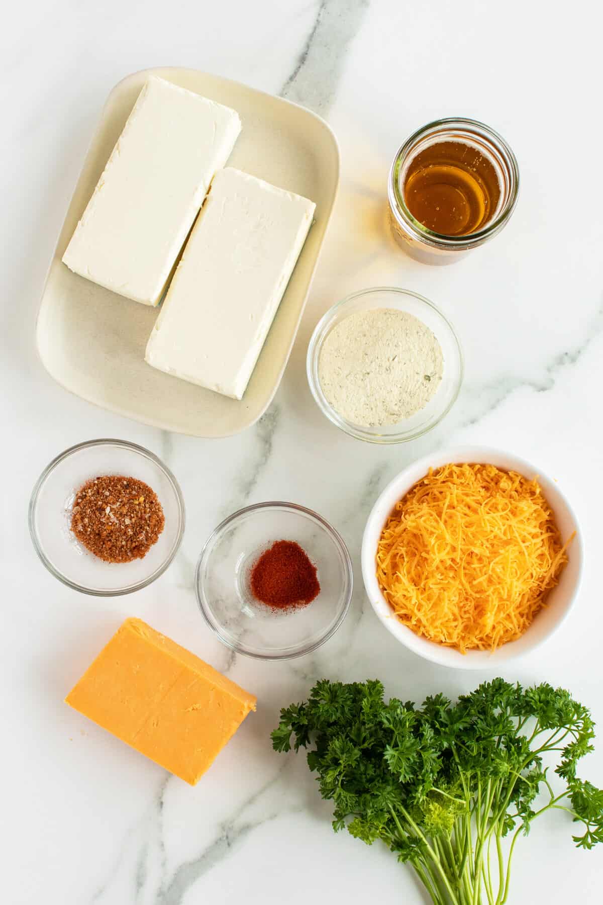 beer cheese dip ingredients in small clea and white bowls