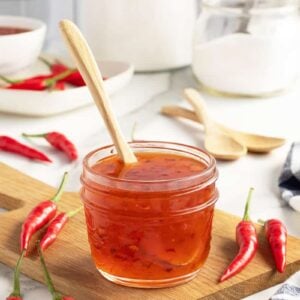 sweet chili sauce in a small mason jar with wooden spoon