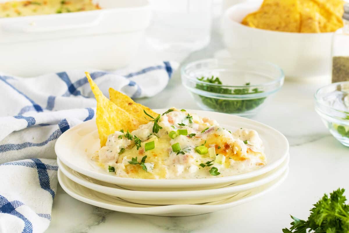 Shrimp dip on a stack of white plates