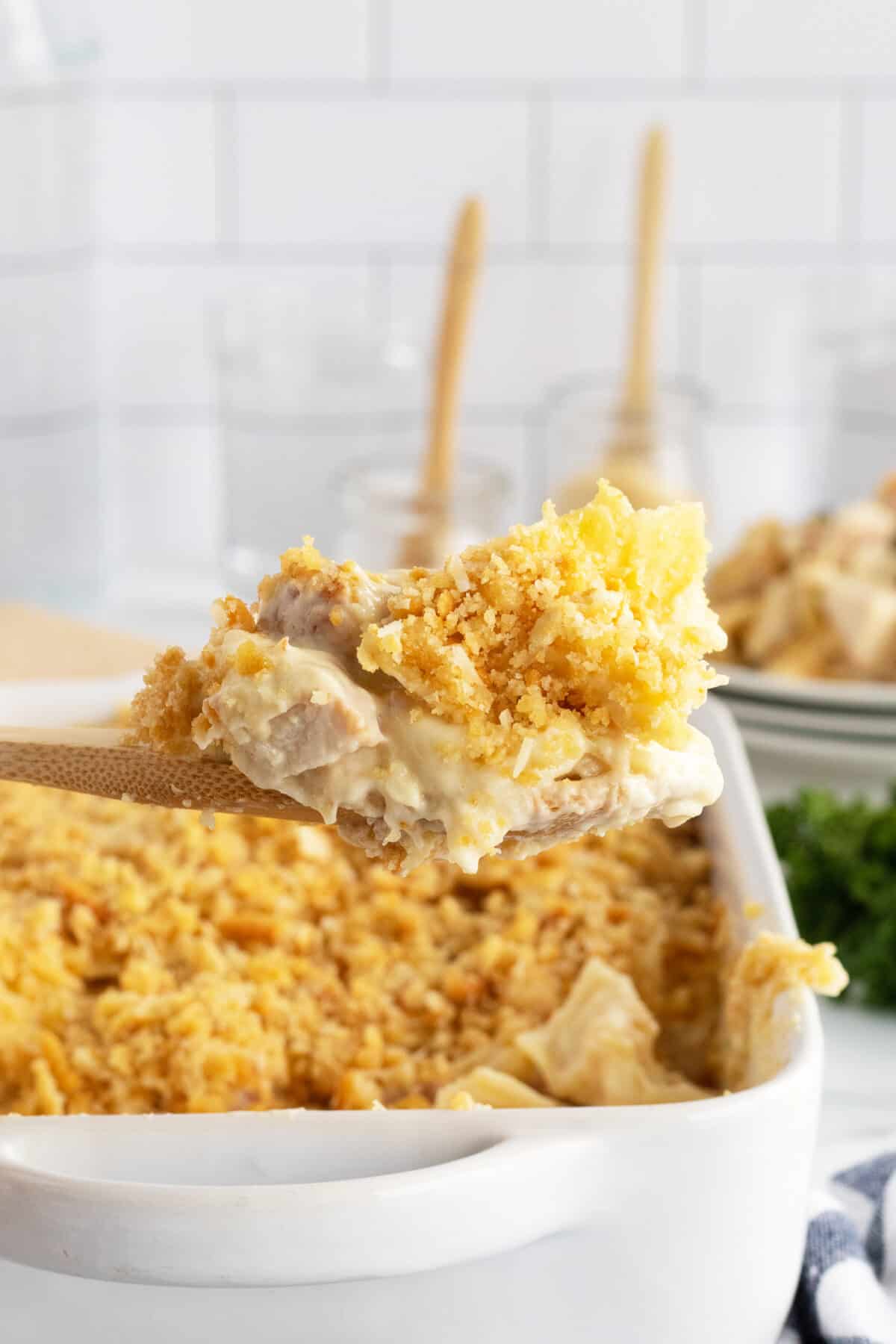 chicken cordon bleu casserole in a white casserole dish with a spoon