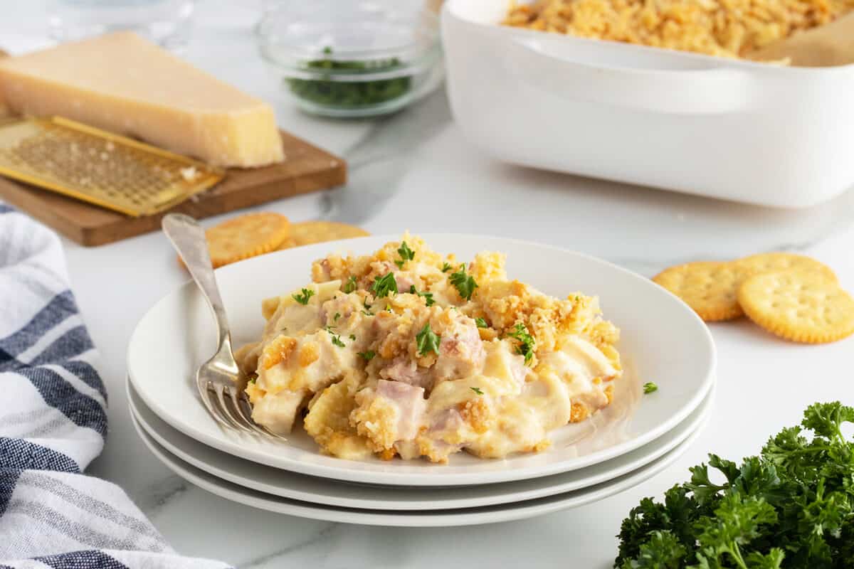 chicken cordon bleu casserole on a stack of white plates