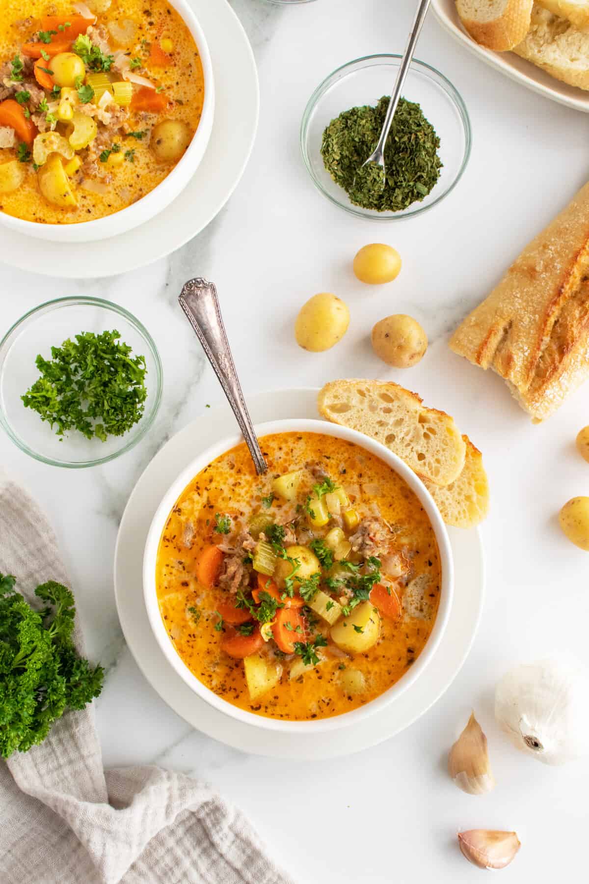 creamy sausage potato soup overhead view with spoon in bowl