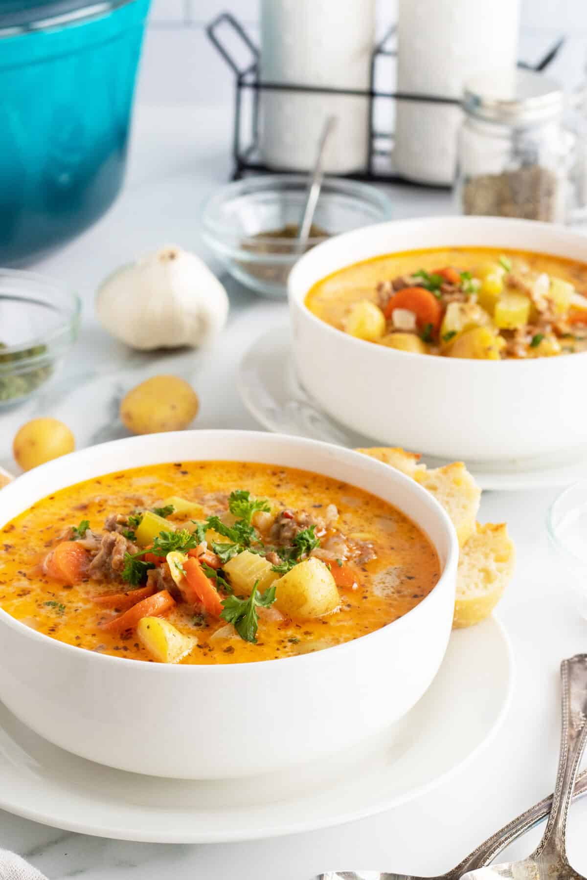 creamy sausage potato soup in two white bowls