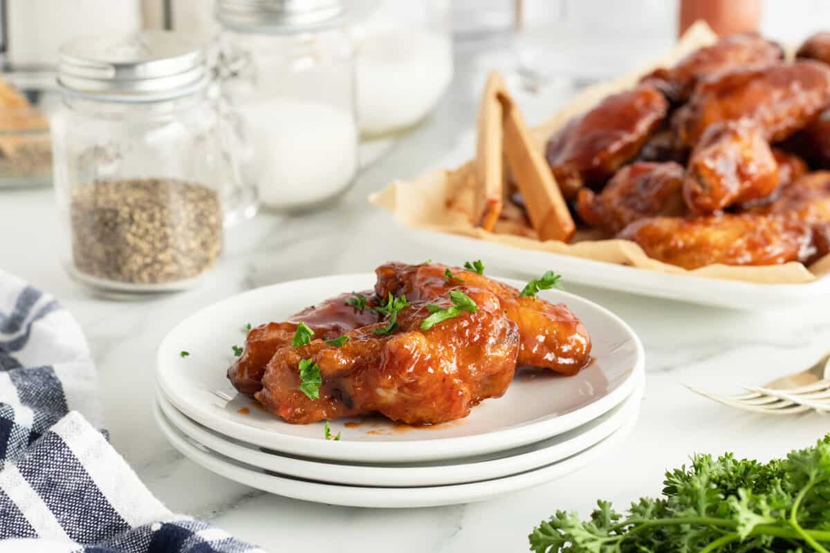 honey bbq wings on a stack of white plates