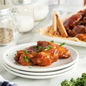 honey bbq wings on a stack of white plates