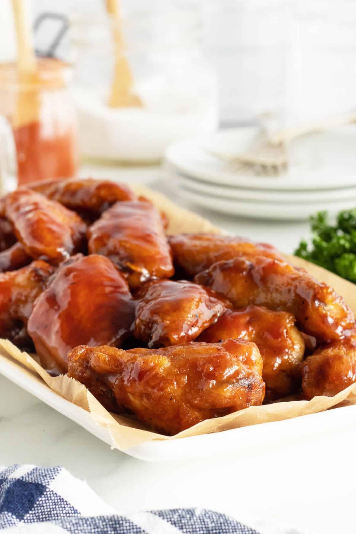 Honey BBQ wings on a white platter close up