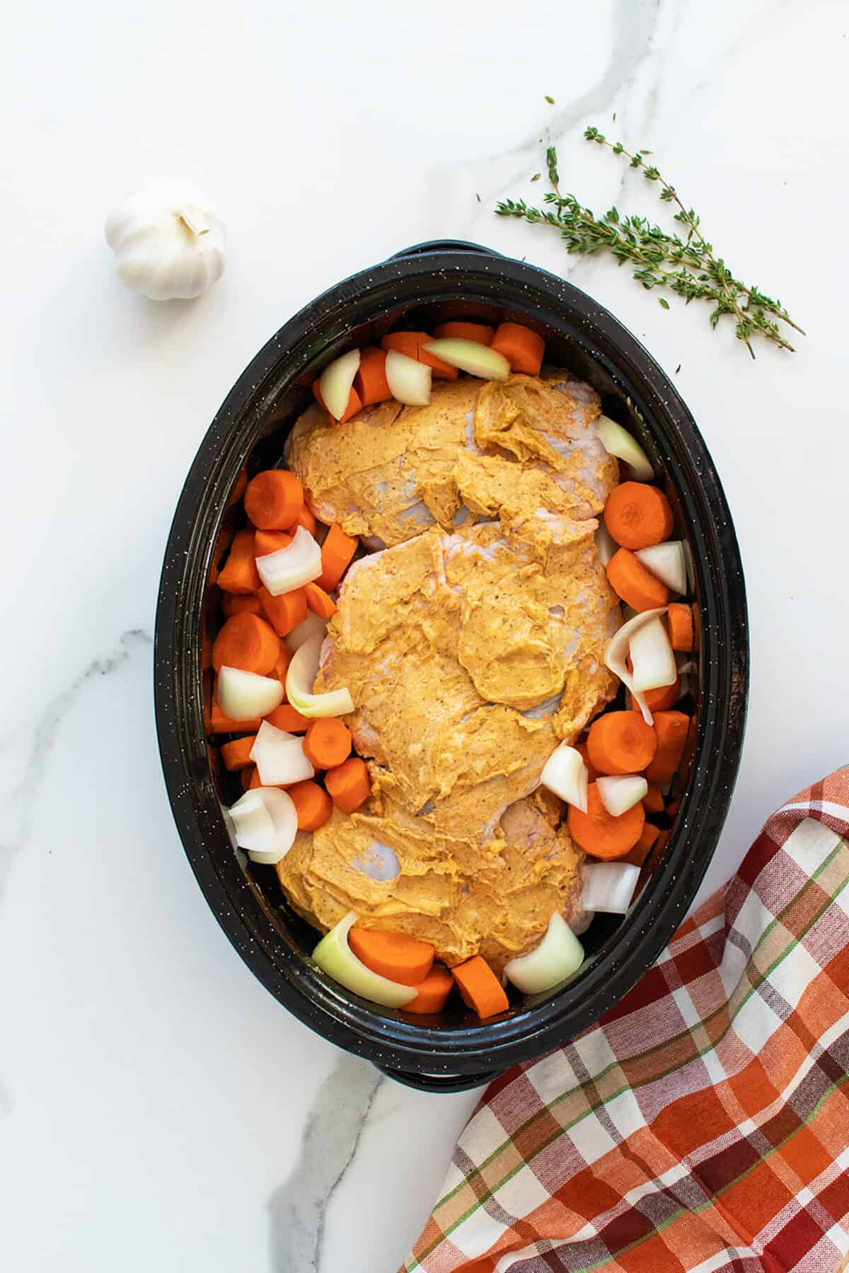 roasted turkey thighs seasoned and in a baking pan with vegetables