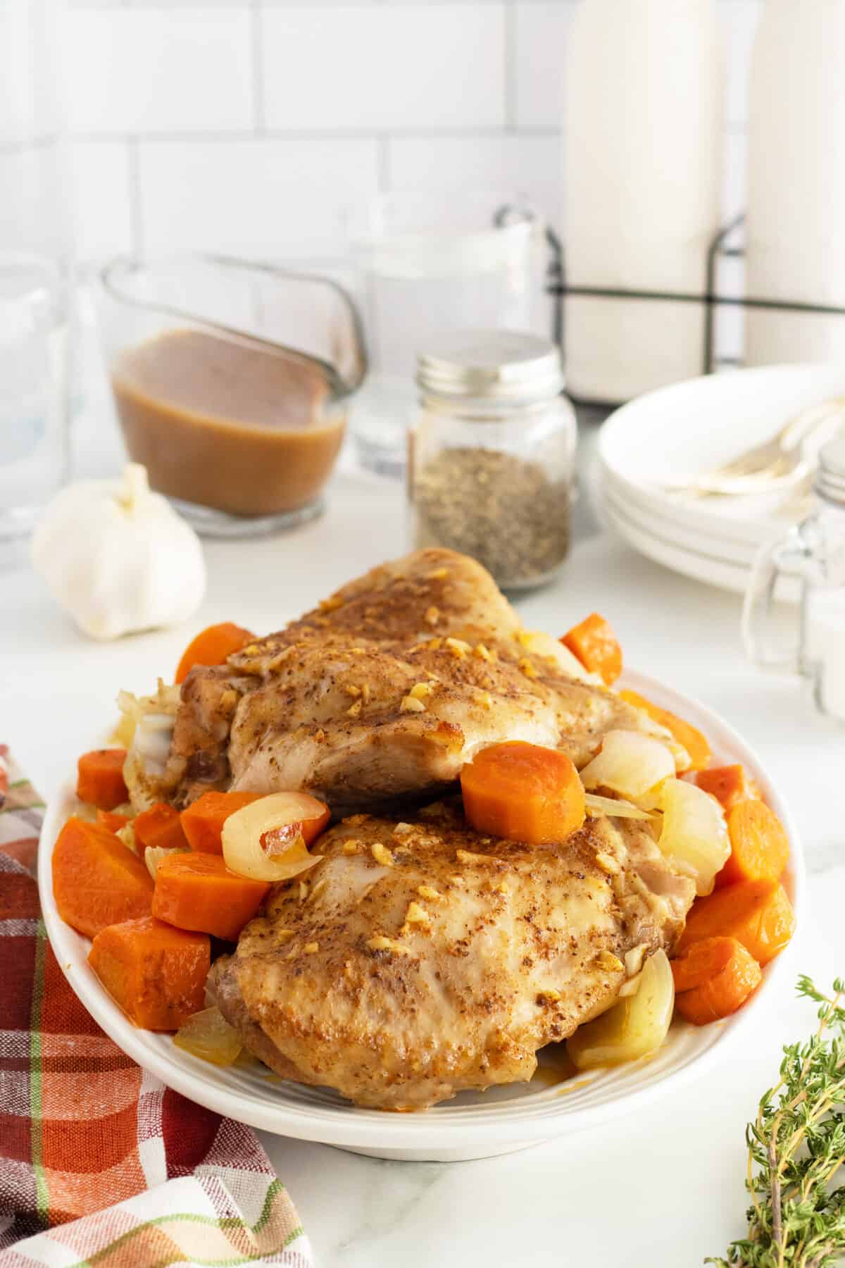 roasted turkey thighs on a white platter with sliced cooked carrots around