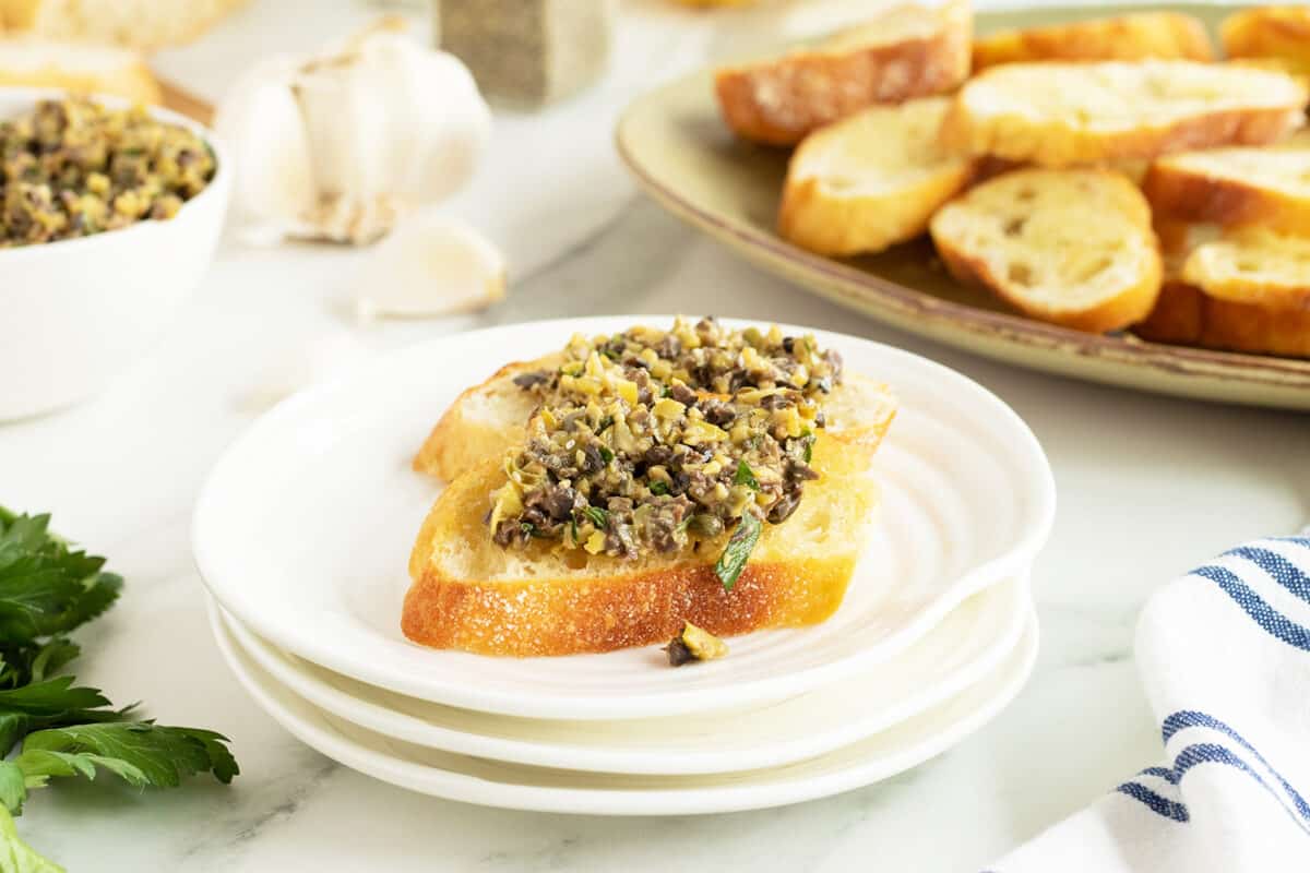 tapenade on a slice of baguette on a white plate