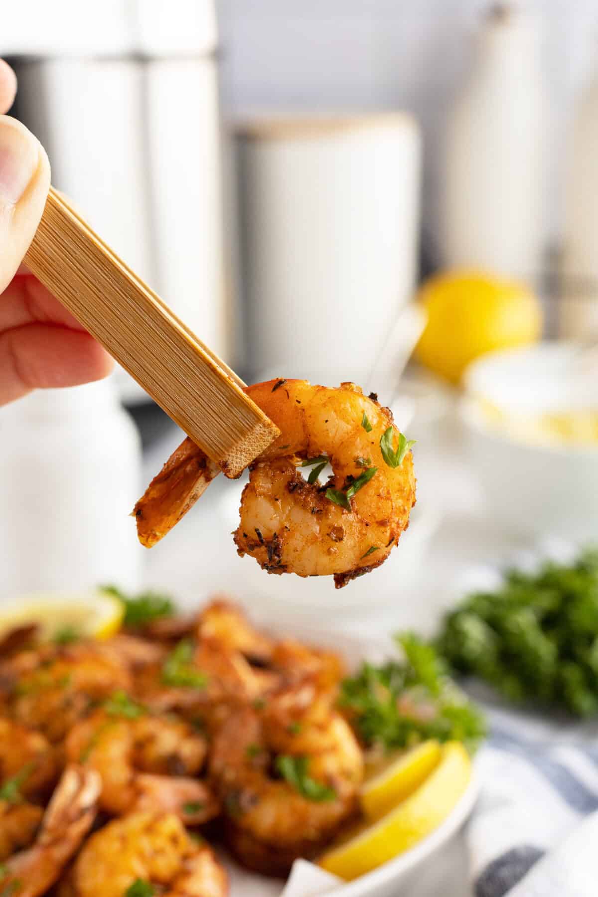 Air fryer shrimp held in chopsticks