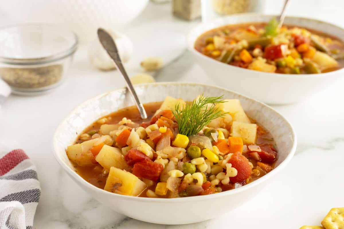 alphabet soup in a large whte bowl with a spoon