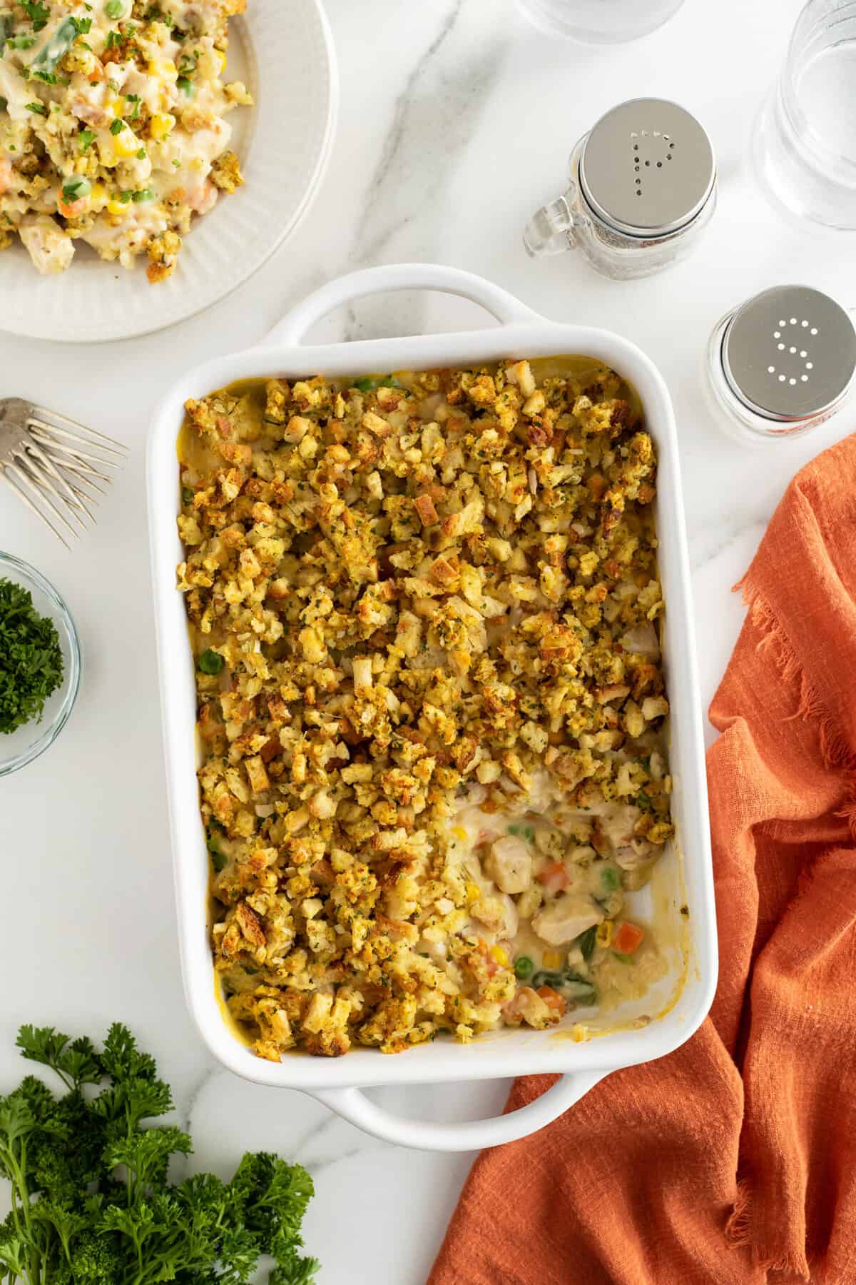 Chicken and stuffing casserole in a white baking pan with a slice out