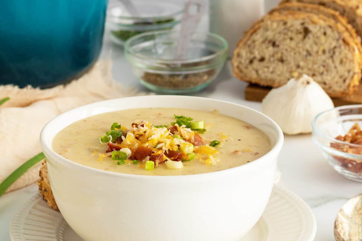 cream of potato soup in a white bowl with toppings